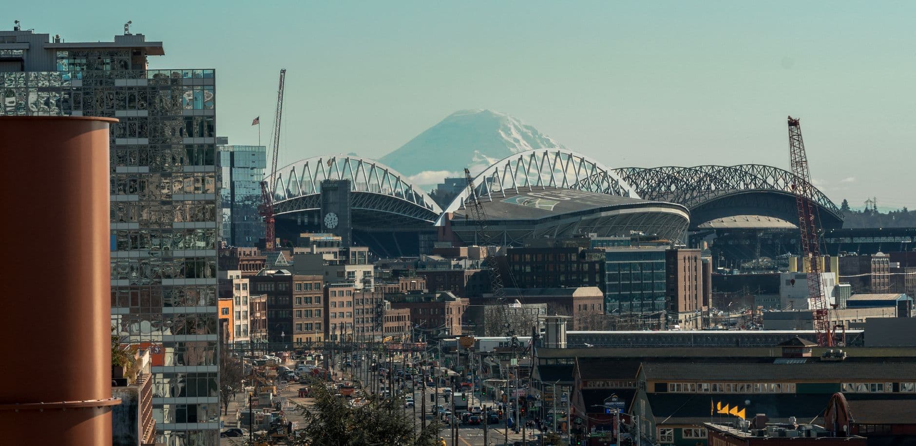 Seattle cityscape featuring Lumen Field and Mount Rainier under a clear sky.